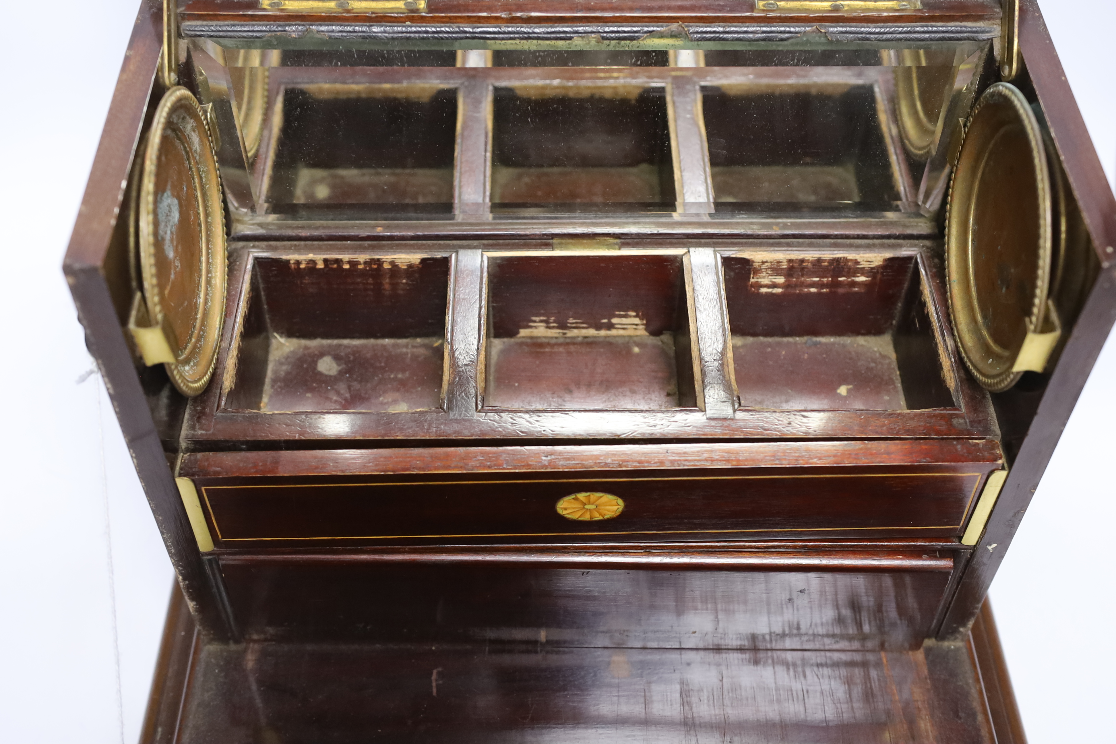 An Edwardian Sheraton revival inlaid mahogany portable drinks cabinet with tantalus and other accessories including serving trays, a brass cribbage board, with secret drawer, etc, 37cm high